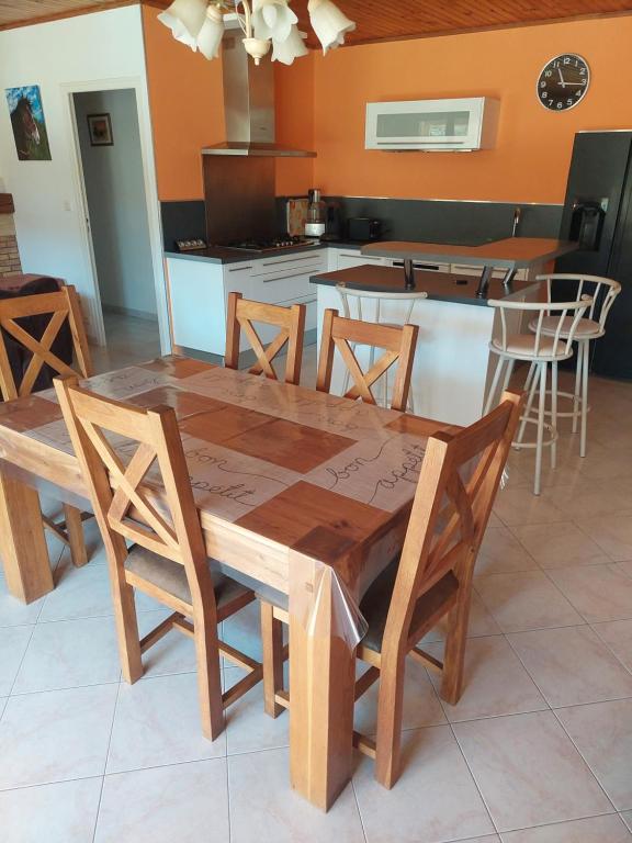 a wooden table and chairs in a kitchen at Villa de vacances avec piscine chauffée proche d Anduze in La Barriére