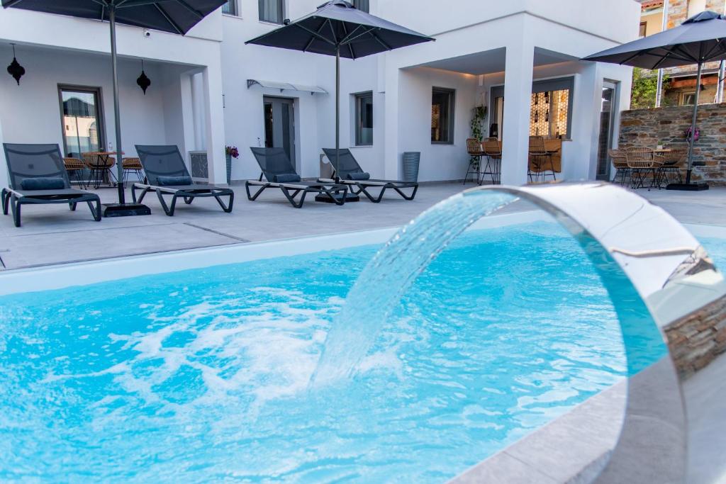 uma piscina com uma fonte de água em frente a uma casa em Kea Paradise em Korissia