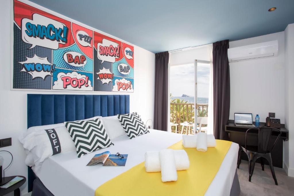 a bedroom with a large bed with a yellow desk at Casual Pop Art Benidorm in Benidorm
