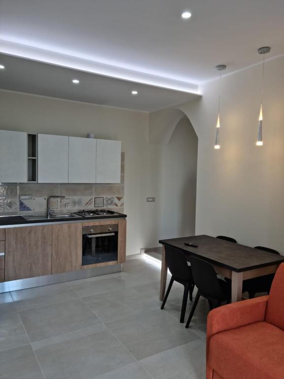 eine Küche mit einem Holztisch und einem Esszimmer in der Unterkunft Casa Sofia in Gaeta