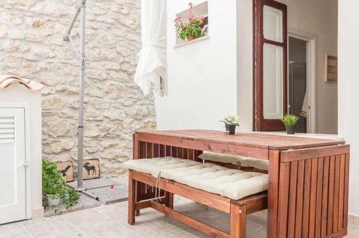 a bathroom with a wooden bench and a mirror at [DOWNTOWN SELINUS] Bright apartment with courtyard in Marinella di Selinunte