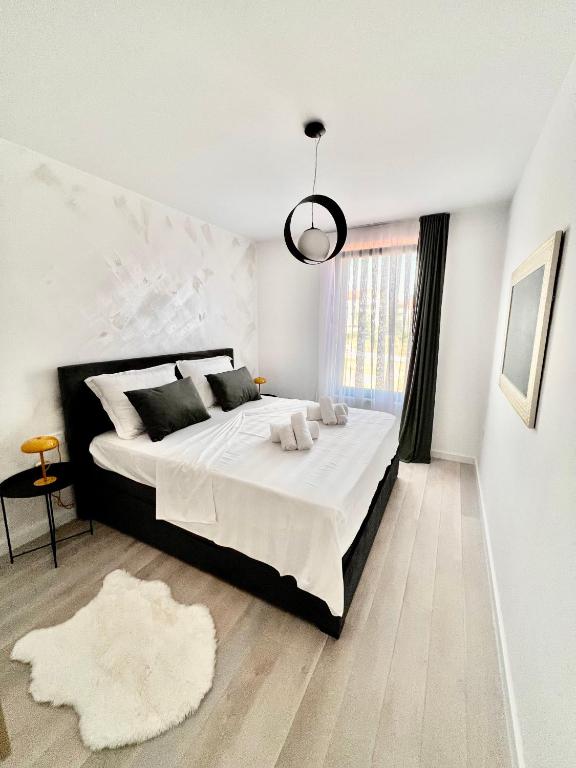 sypialnia z dużym łóżkiem z białą pościelą i oknem w obiekcie Apartmani CUBE A w Medulinie