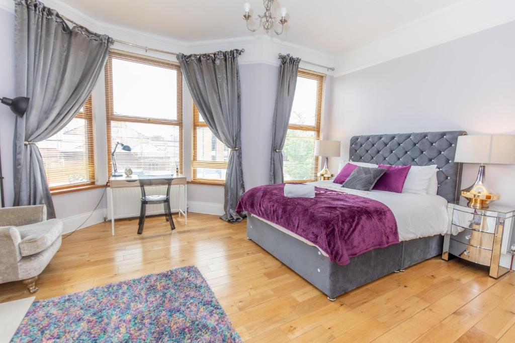 a bedroom with a large bed with purple sheets at SO-LUX in Belfast