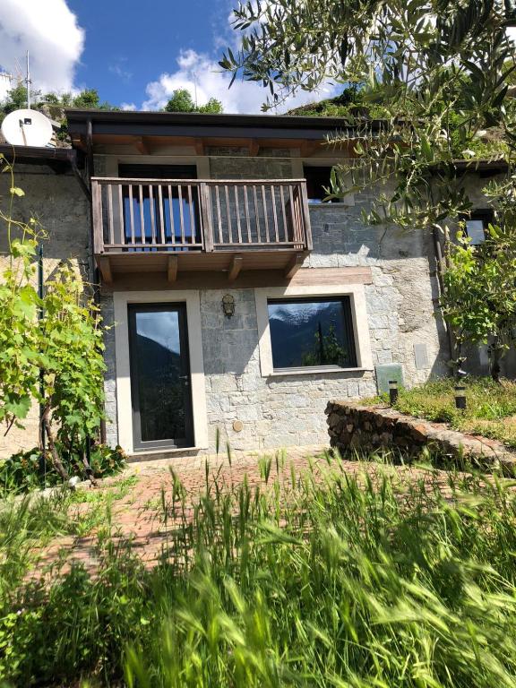 a stone house with a balcony on top of it at Casa dell'Olivo in Castione Andevenno