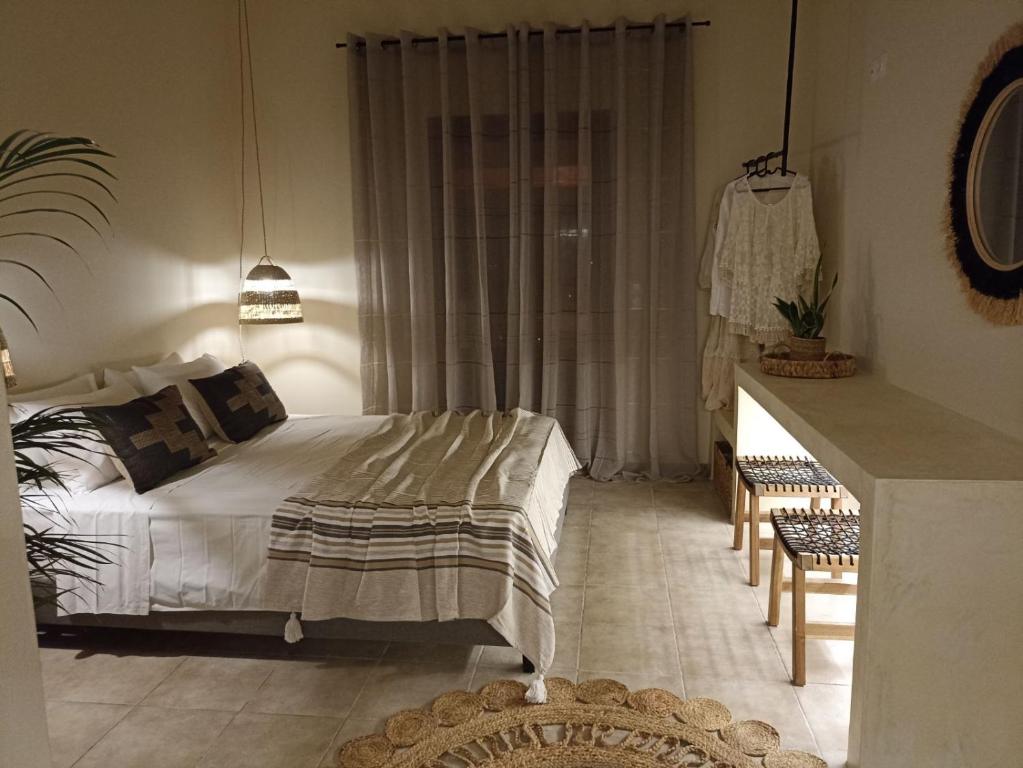 Petra Lodge في فينيكاس: غرفة نوم بسرير وطاولة في غرفة