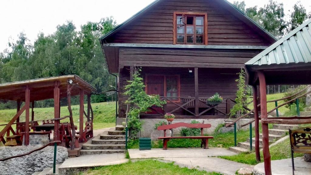 una pequeña casa con una mesa de picnic y un banco en Sodyba pas Juozą, en Milkai