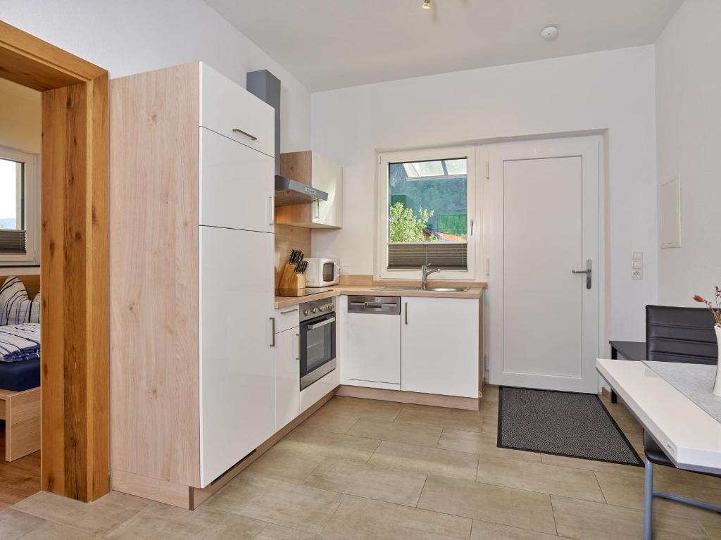 uma cozinha com um frigorífico branco e uma mesa em Apartment Isabella em Umhausen