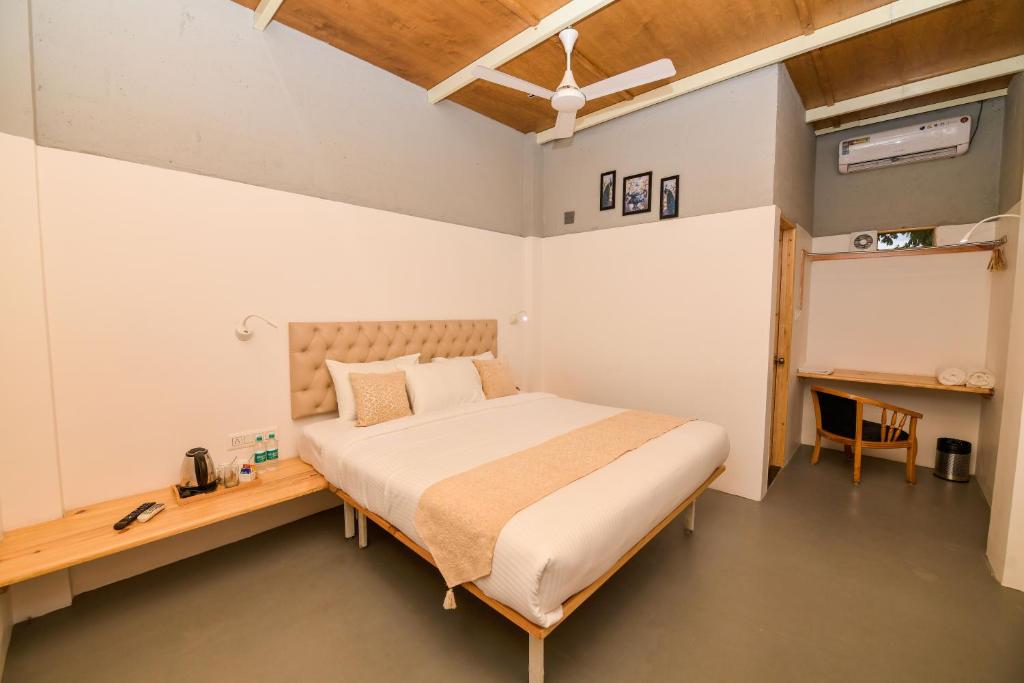 a bedroom with a bed and a wooden desk at Shine Residency in Mysore