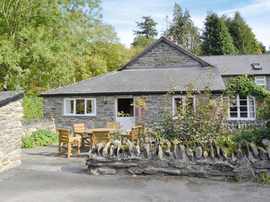 a stone cottage with a table and chairs in front of it at Stable Cottage in Corwen