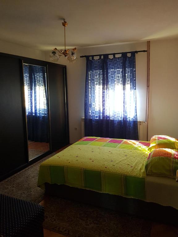 a bedroom with a bed and a large window at Apartman Petar in Trebinje