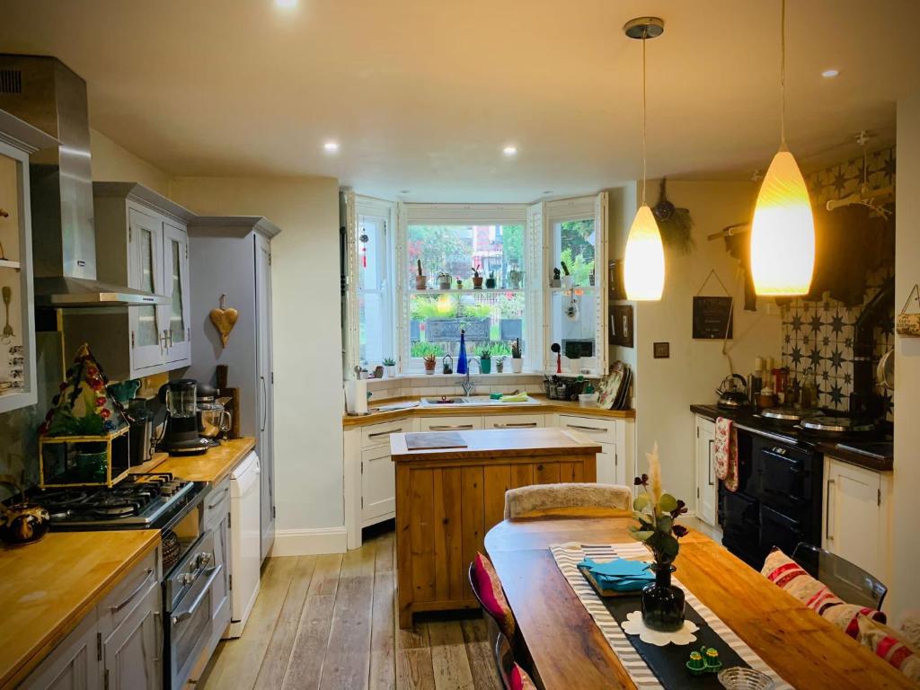 a kitchen with white cabinets and a table and a window at The green house in Portsmouth