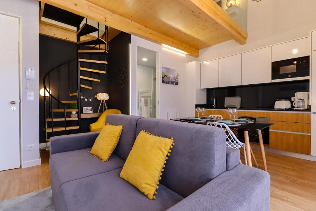 uma sala de estar com um sofá azul e uma cozinha em Coutinho Apartment - Modern Ap in the City Centre with Balcony em Viana do Castelo