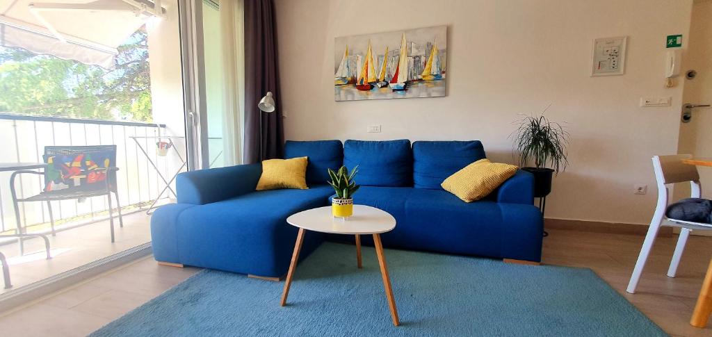 a blue couch in a living room with a table at Apartment Rosie in Split