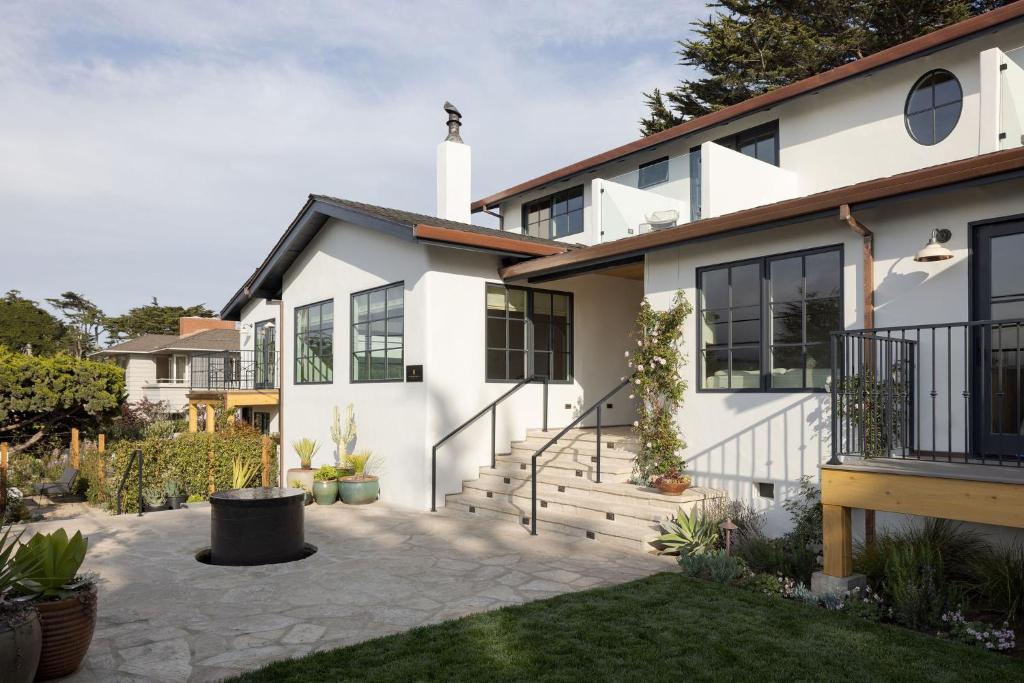 una casa blanca con una escalera en un patio en Villa Mara Carmel, en Carmel