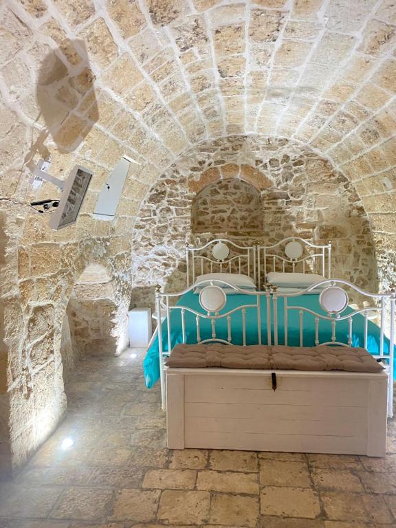 a bedroom with a bed in a stone wall at Pietrabianca Suite in Modugno