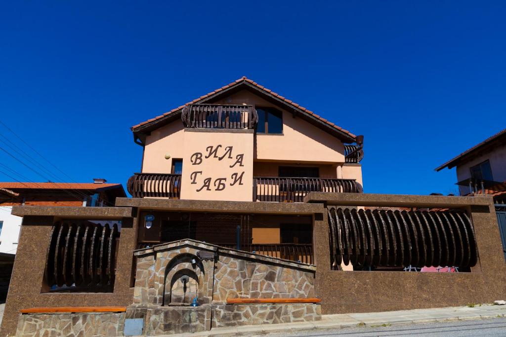 a building with a clock on the side of it at Guesthouse Gaby in Sapareva Banya