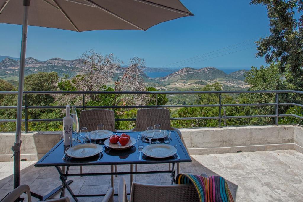 una mesa azul con platos de comida en el balcón en Cote Nebbiu en Barbaggio