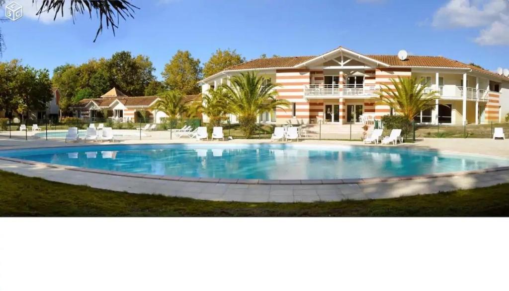 una gran piscina frente a una casa en Soulac-Sur-Mer avec Piscine, en Soulac-sur-Mer