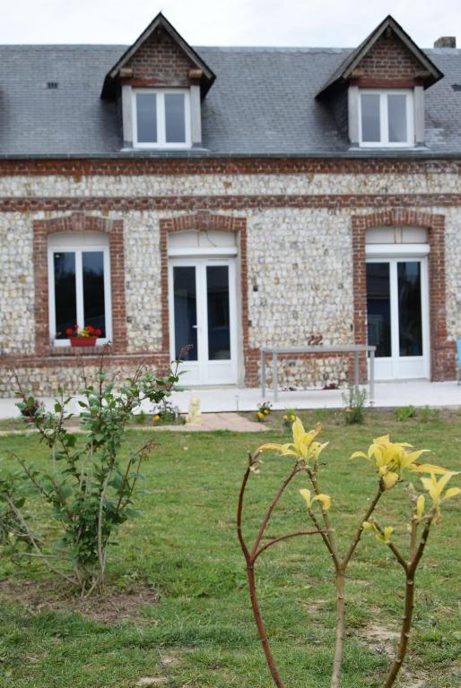 une maison en briques avec des fenêtres et un banc dans une cour dans l'établissement La Salamandre, à Thérouldeville