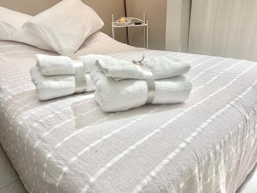 un letto con asciugamani bianchi sopra di Pigna Tommy House a Sanremo
