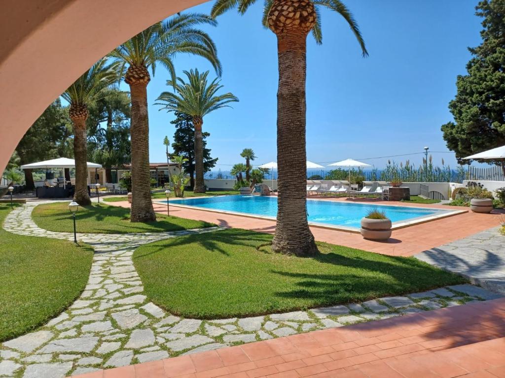 um resort com palmeiras e uma piscina em Villa Martina em Ischia