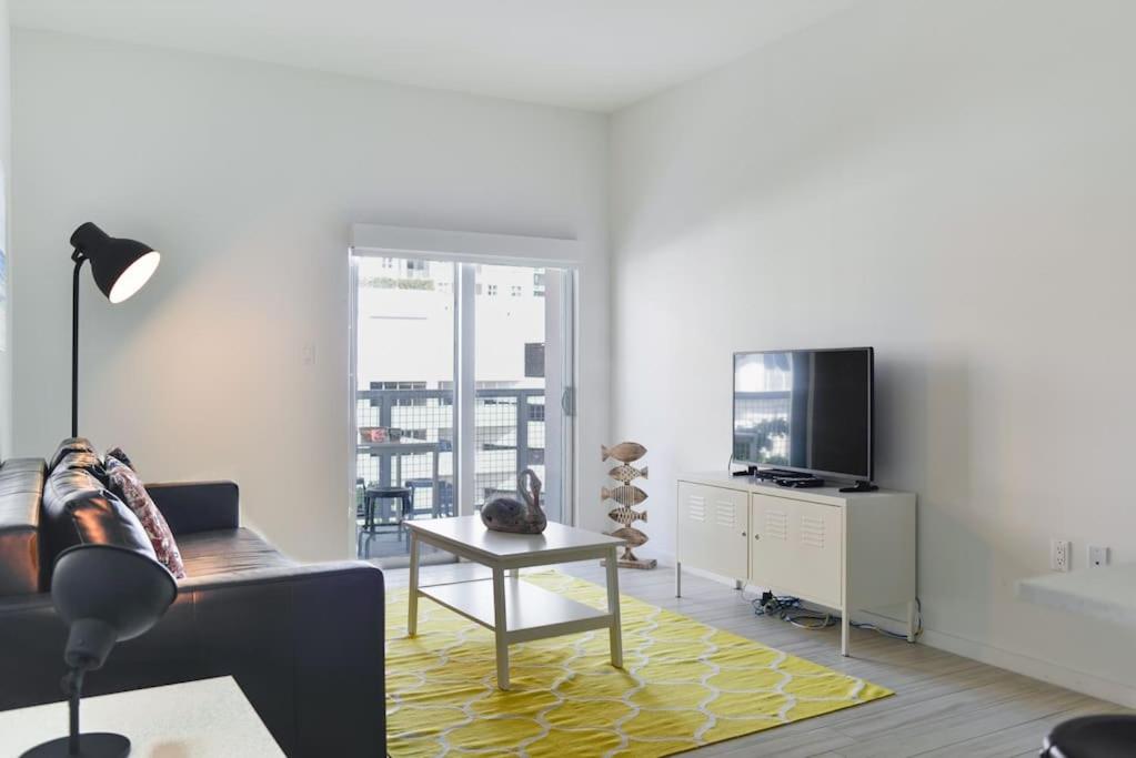 a living room with a couch and a tv at Wynwood Modern 1 Bedroom in Miami