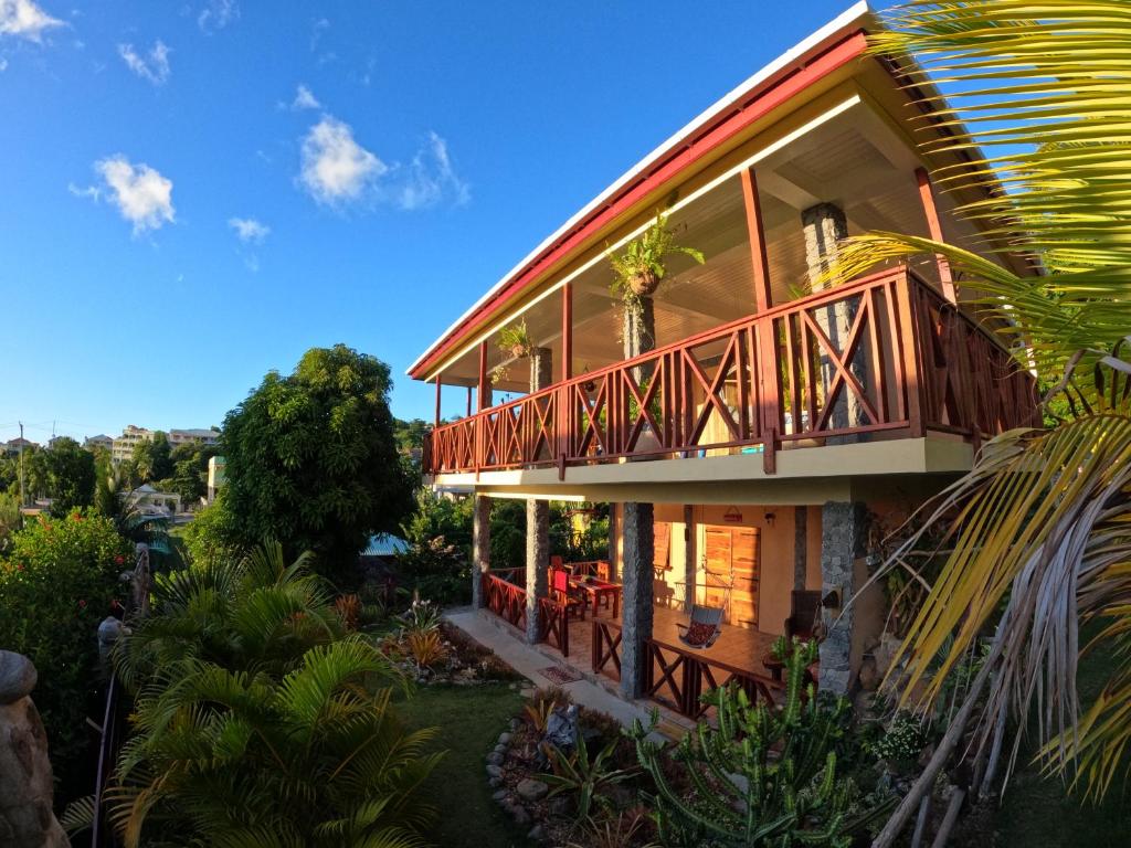 a house with a deck on the side of it at Mabrika Resort Dominica in Guillet