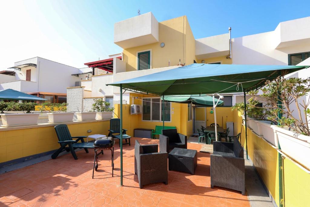 a patio with chairs and a green umbrella at Family apartment in Torre Pali with private 100 sqm garden in Torre Pali 