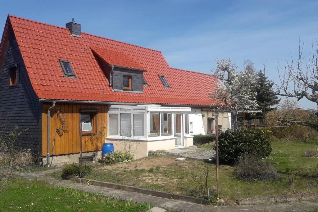 a house with an orange roof with a yard at Ferienhaus Rosi in Blankenburg