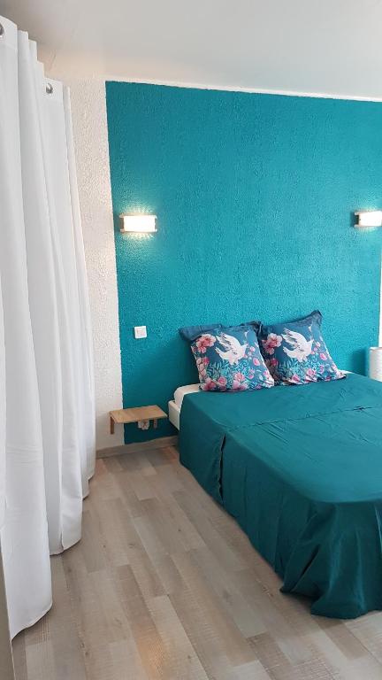 Dormitorio azul con cama y pared azul en appartement entre Mer et Corbières, en Cuxac-dʼAude