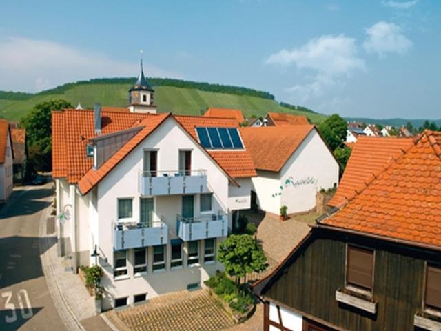 un groupe de bâtiments avec des toits orange et une église dans l'établissement Pension Gästehaus Kachelofa, à Vaihingen-sur-l'Enz