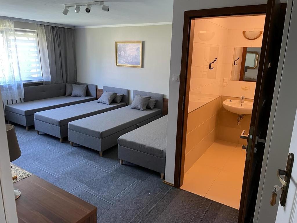 a hotel room with two beds and a sink at Pokoje gościnne in Dźwirzyno
