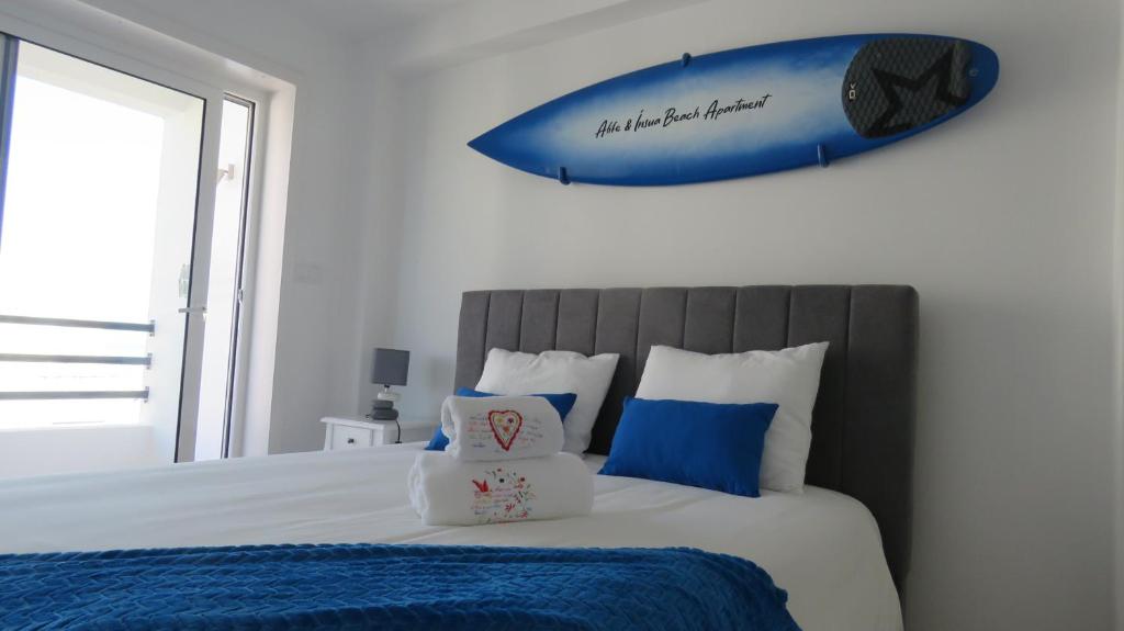 a bedroom with a bed with a surfboard on the wall at Afife & Ínsua Beach Apartment in Viana do Castelo