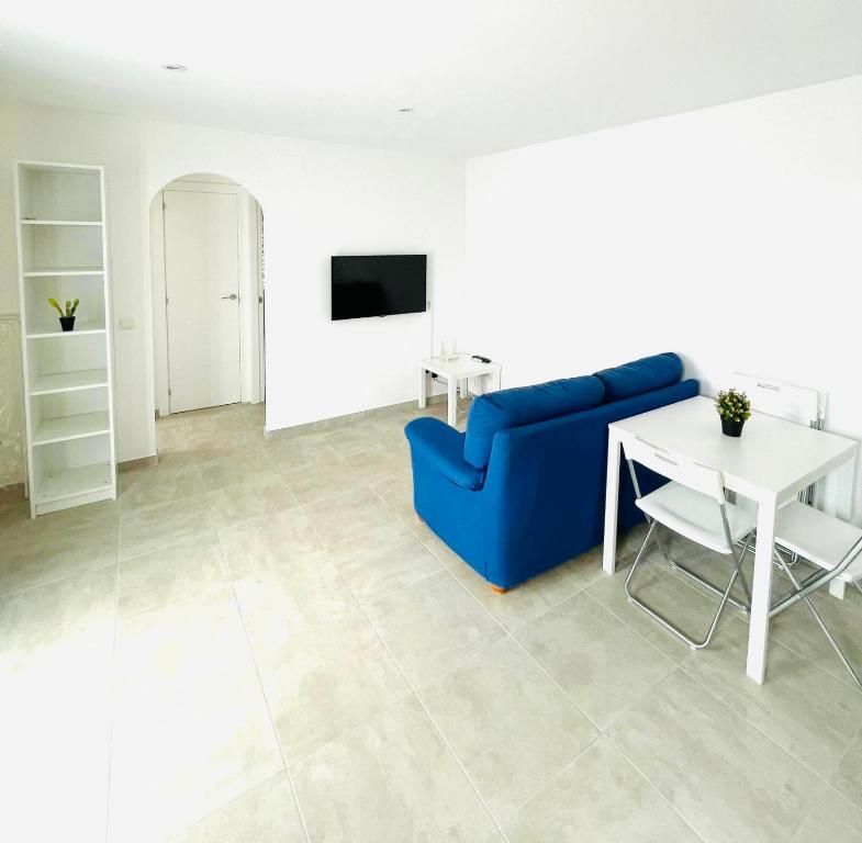 a living room with a blue couch and a table at EL NIU DE LA BERTA in Bellcaire dʼEmpordà