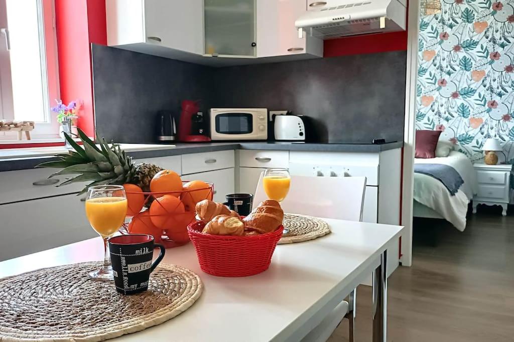 - une table avec une corbeille de fruits et deux verres de jus d'orange dans l'établissement Appartement Place du Marché, à Mers-les-Bains