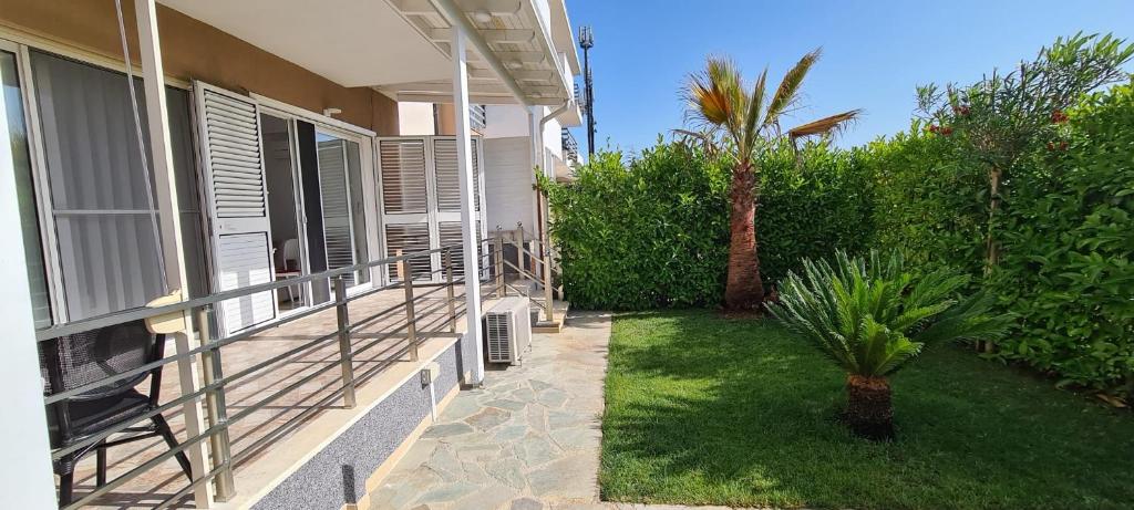 een veranda van een huis met een palmboom bij Gjiri i Lalzit Lura 3 Apartment Toni in Durrës