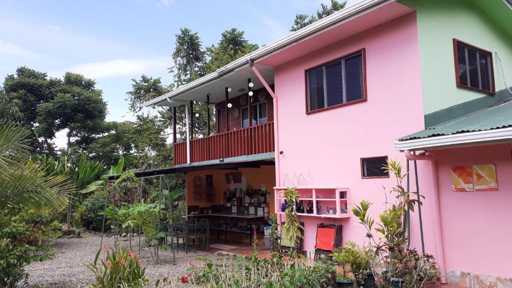 Edificio rosa y verde con balcón en Dolce Uvita, en Uvita