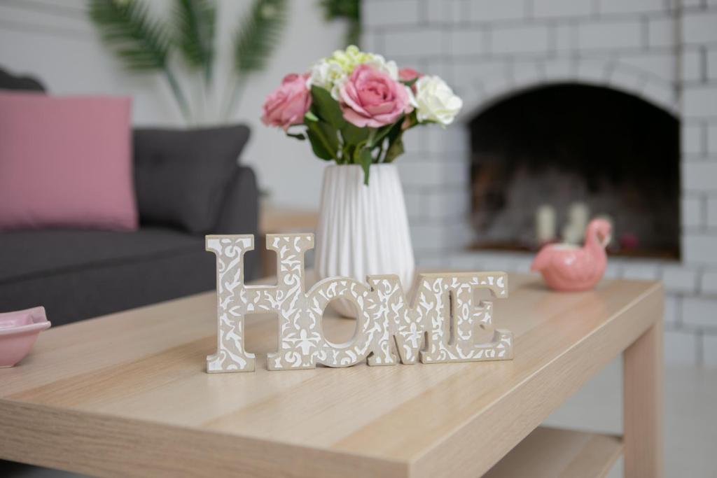 a table with a vase of flowers and a word love on it at Home Sweet Home in Ierápetra