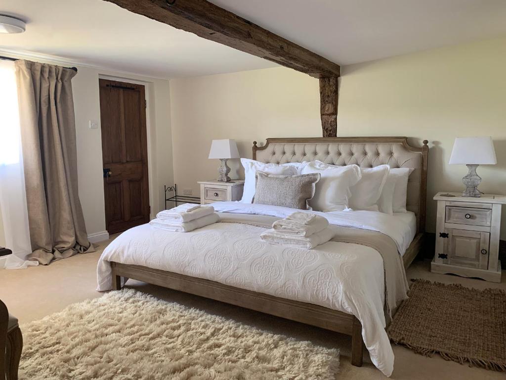 a bedroom with a large white bed with white pillows at Church Farm in Thurlton