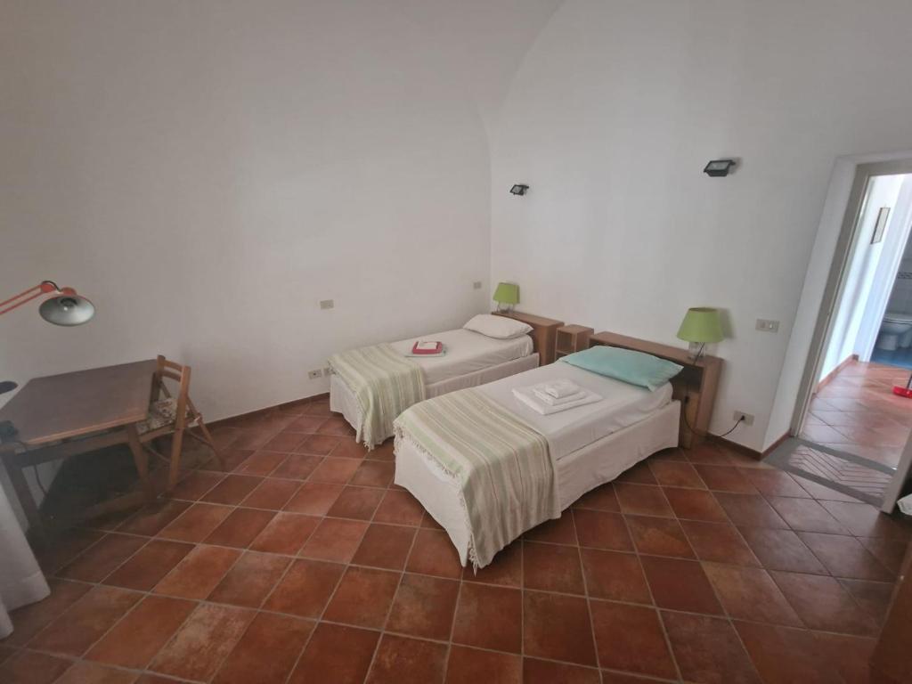 2 Betten in einem Zimmer mit Fliesenboden in der Unterkunft Le Anfore in Anacapri