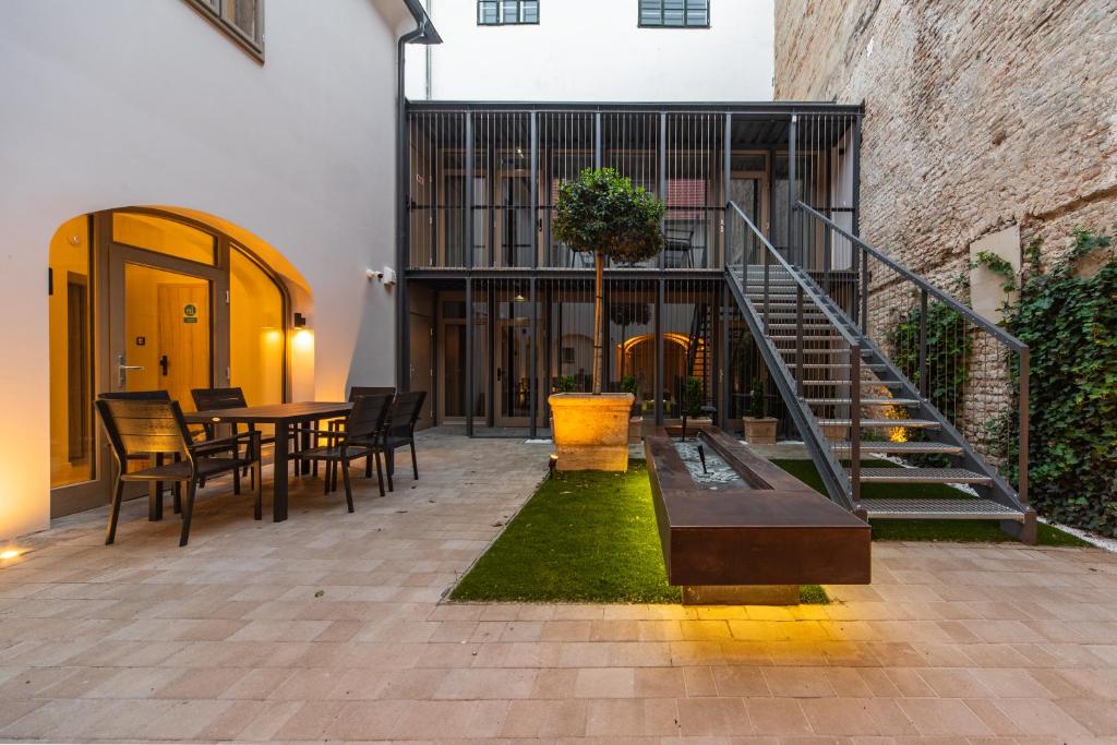 a patio with a table and chairs and a staircase at r12 Apartments in Győr