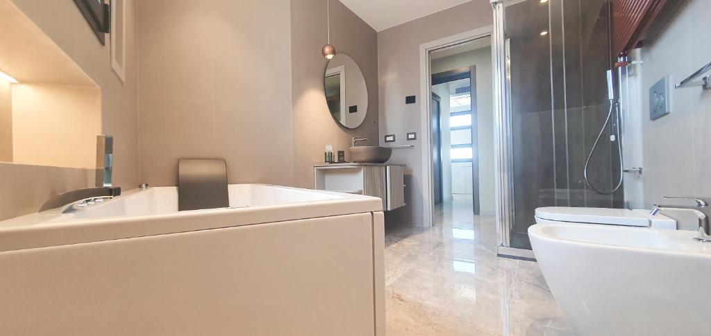 a bathroom with a sink and a toilet and a mirror at Solmaris Tropea Rooms & Suites in Tropea