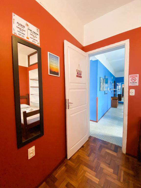 フォルタレザにあるRefugio Hostel Fortalezaのオレンジ色の壁と鏡が特徴の客室です。