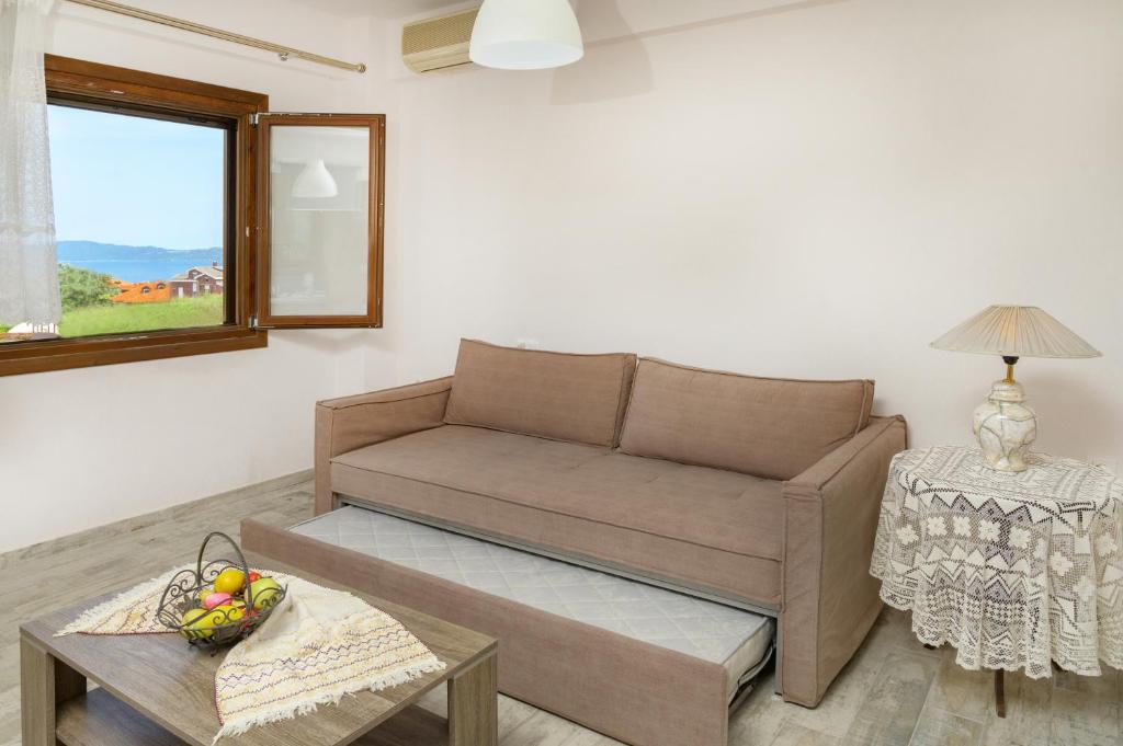 a living room with a couch and a table at DANAI HOUSE 3 in Nea Roda