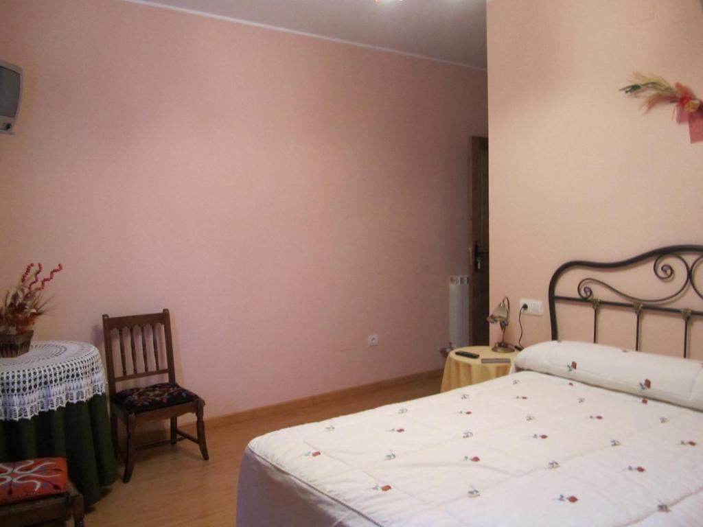 a bedroom with a bed and a table and a chair at Hotel Rural El Molinero de Santa Colomba de Somoza in Santa Colomba de Somoza