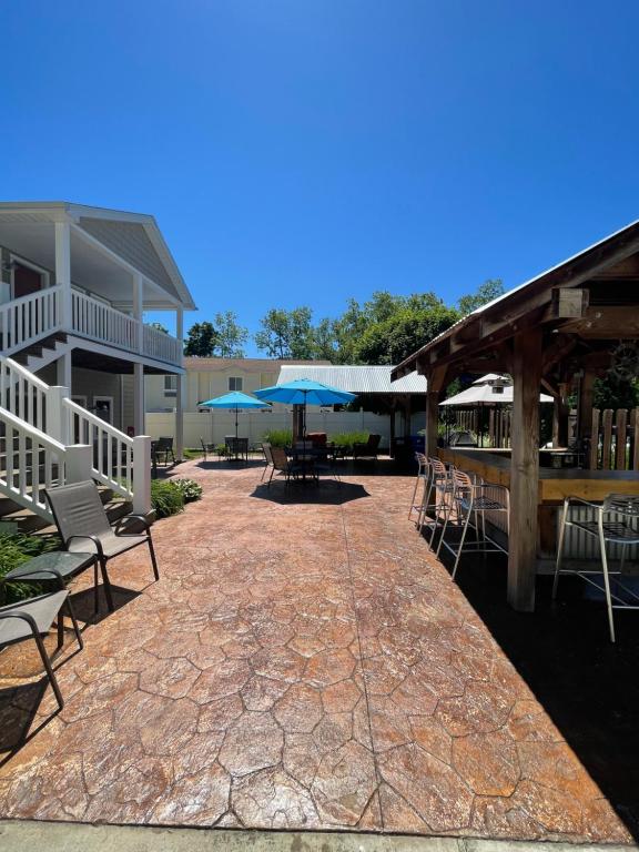 eine Terrasse mit Stühlen und Sonnenschirmen vor einem Gebäude in der Unterkunft Bodee's Bungalow Adults Only Couples Only Boutique Hotel in Put-in-Bay