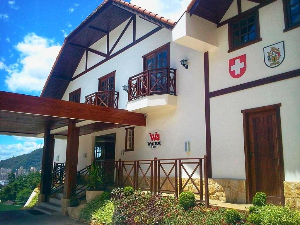 ein großes weißes Gebäude mit einem roten Kreuz darauf in der Unterkunft Hotel Willisau in Teresópolis