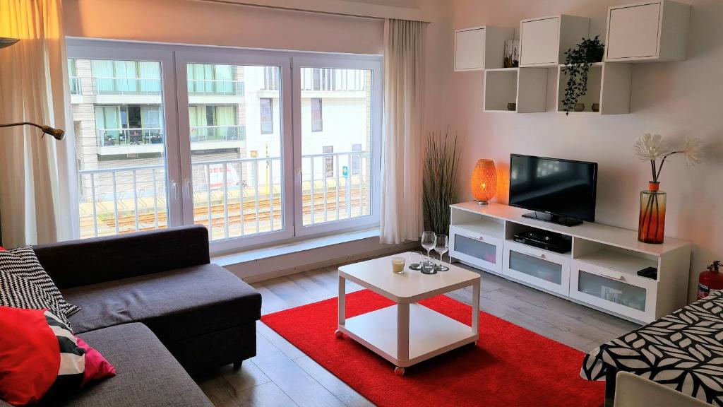 a living room with a couch and a tv at Appartement 2 chambres 200m plage Nieuwpoort Bad in Nieuwpoort