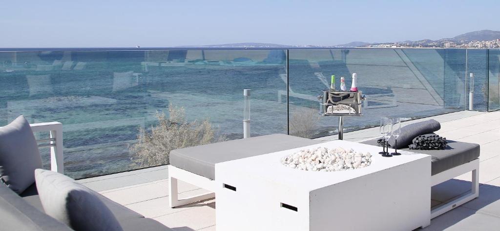 a white table on a balcony with a view of the ocean at Villa Molinar in Palma de Mallorca
