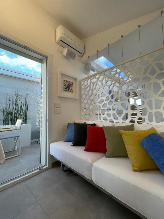 a living room with a couch with colorful pillows on it at Ellenove holiday house in Tortoreto Lido